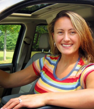 woman smiling looking out a car window.