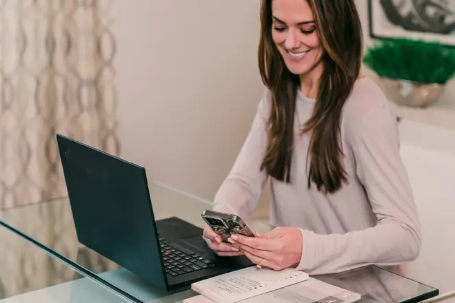 Woman using her cell phone to contact her local Molly Maid for cleaning services.