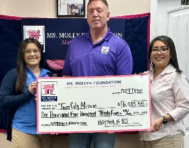 Molly Maid staff presenting a check to Twin City Mission.