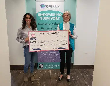 Molly Maid staff members holding a check at Fort Bend Women's Center.