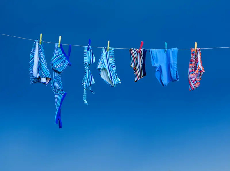 Bathing suits hanging on a clothes line.