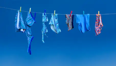 Bathing suits hanging on a clothes line.