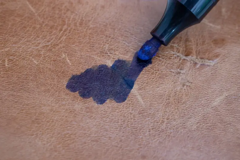 Blue permanent marker stain on leather couch.