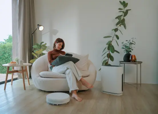A woman working on a tablet, sitting in a clean home office environment with a relaxed pose